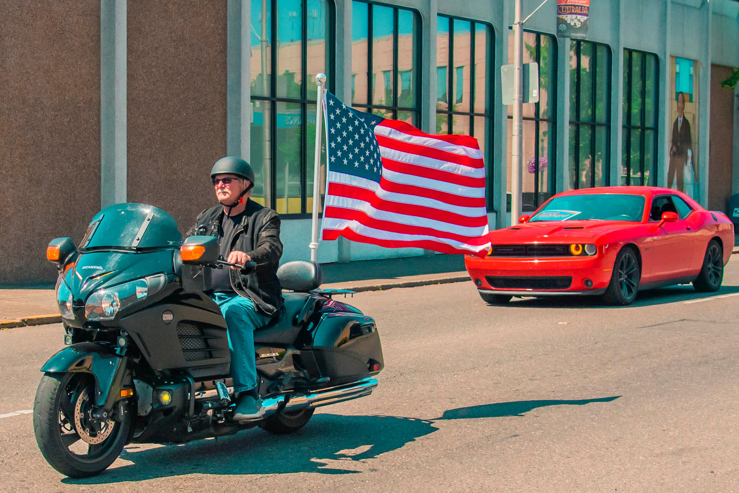 A rider displays an American flag on his motorcycle as he rides through downtown Centralia during a “Patriotic Drive” part of Summerfest in Centralia for Fourth of July, Sunday afternoon.